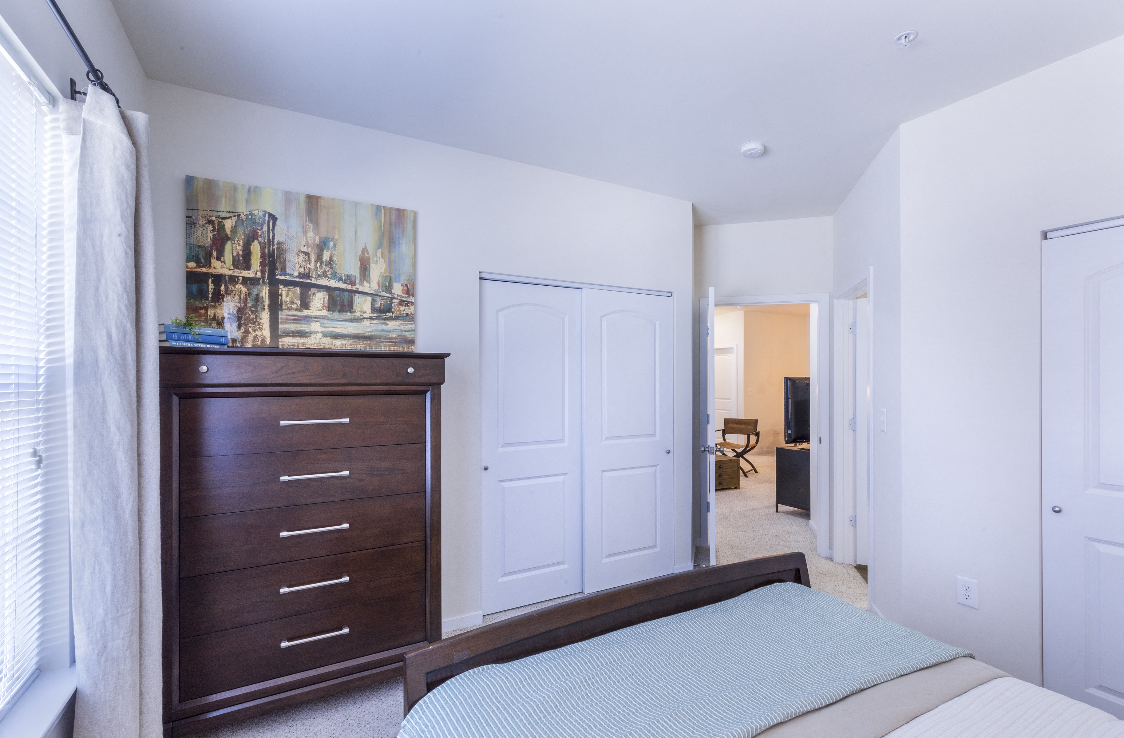 a bedroom with a bed and a dresser and a closet at Aventura at Towne Centre, Ellisville, 63011